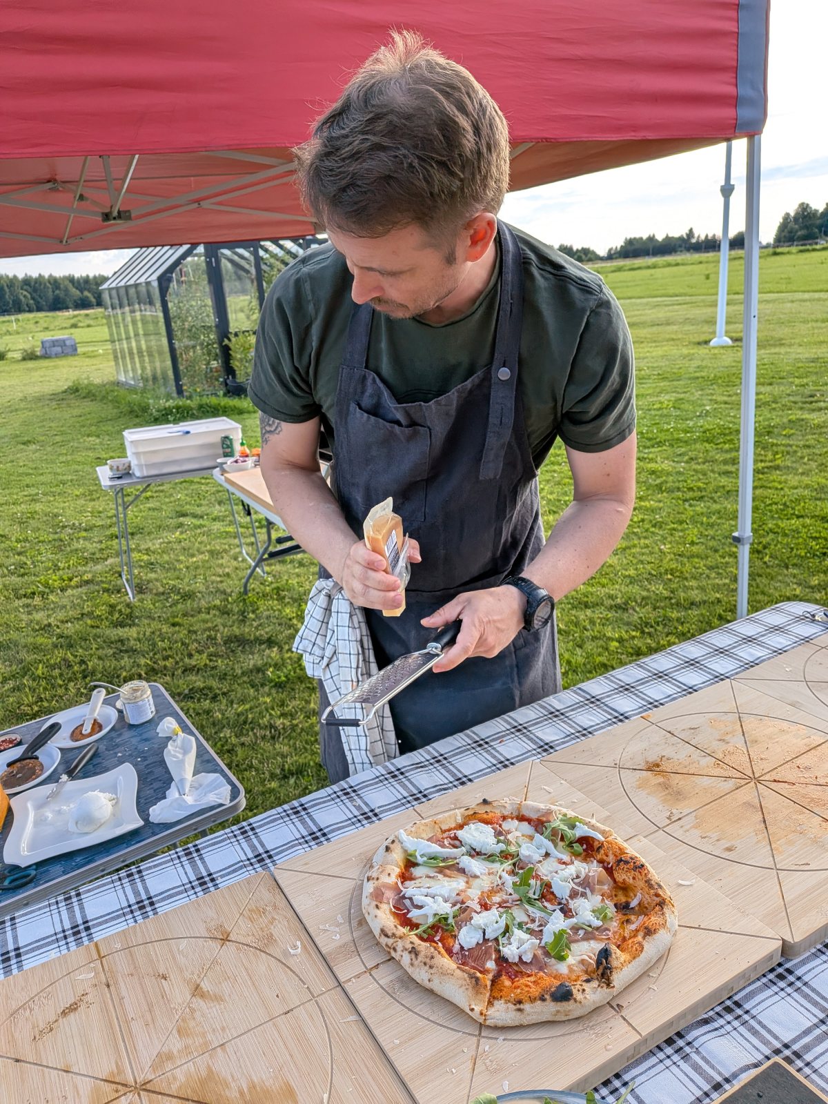 Värske pitsa laual, taustal valmib järgmine